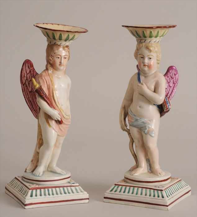 Appraisal: PAIR OF ENGLISH PEARLWARE CUPID CANDLESTICKS Modeled as the semi-draped