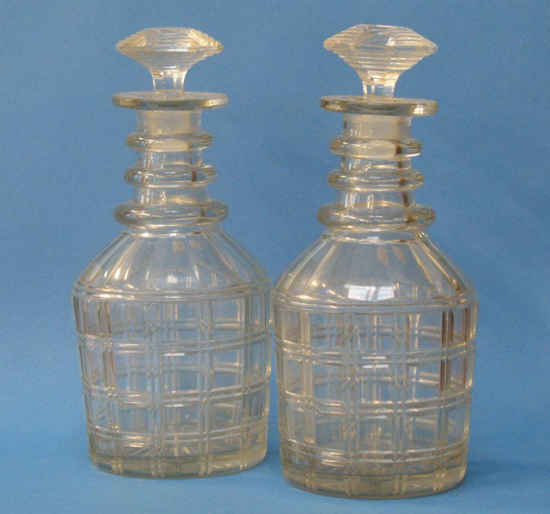 Appraisal: A PAIR OF REGENCY CUT-GLASS DECANTERS with octagonal stoppers ring-mounted