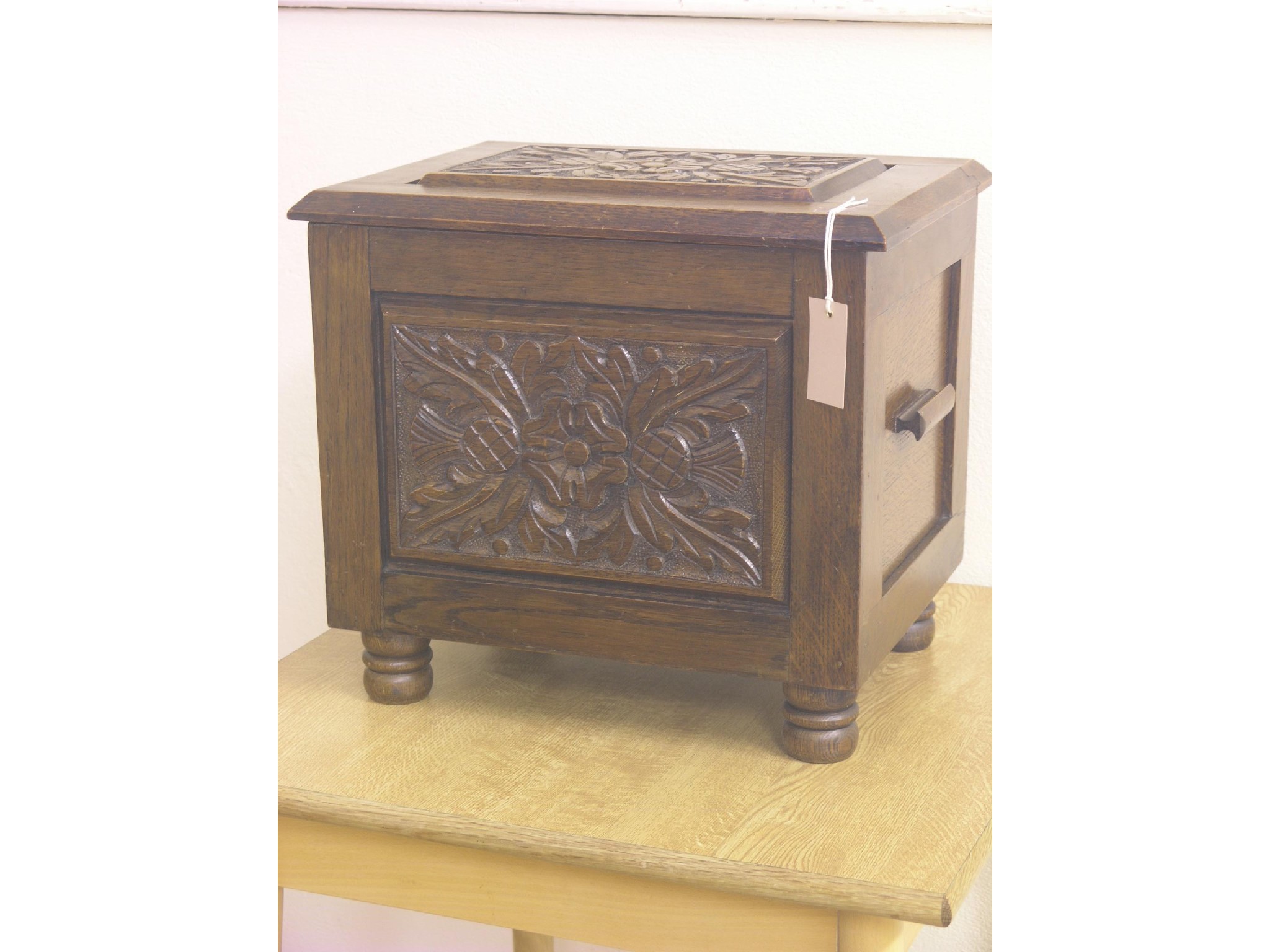 Appraisal: A solid dark oak box-stool with carved panels ft in