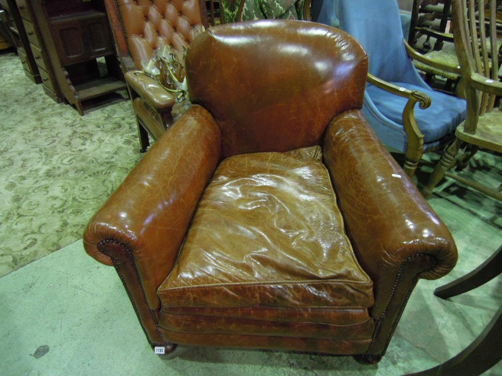 Appraisal: An Edwardian deep seated easy chair with rolled arms brown