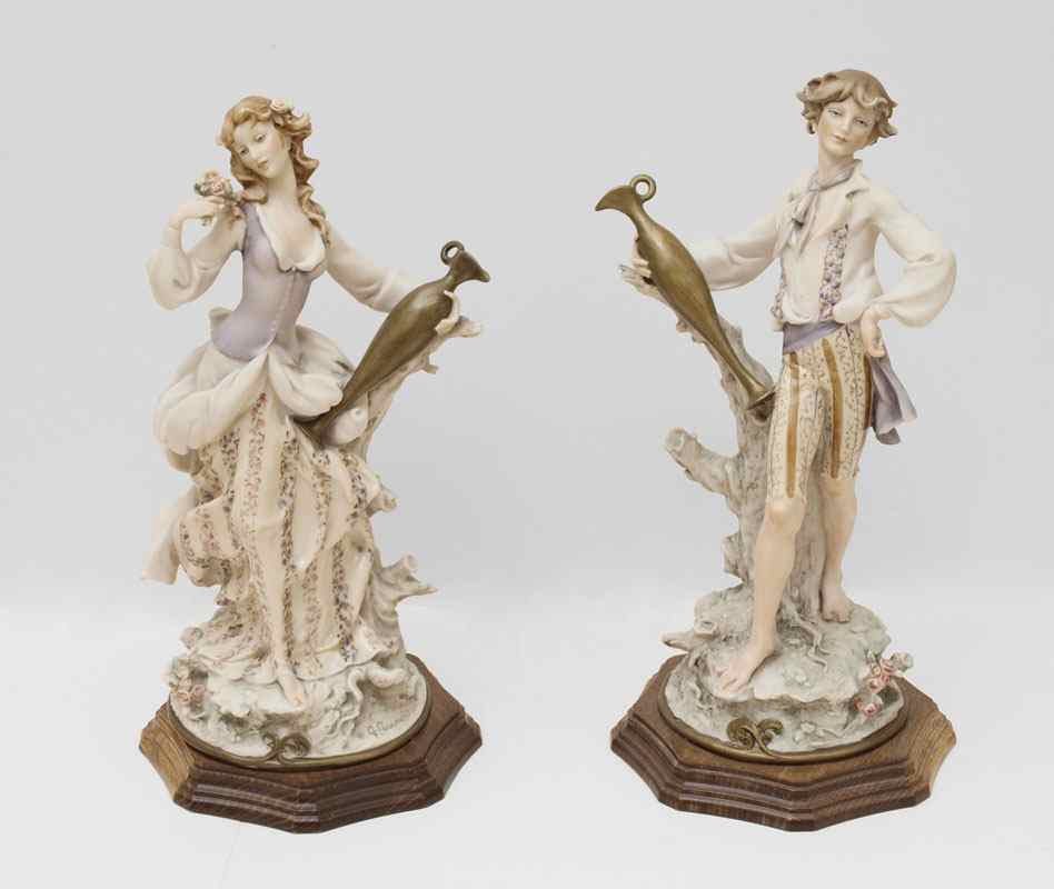 Appraisal: GIUSEPPE ARMANI FIGURAL COUPLE Pair of figurines each holding a