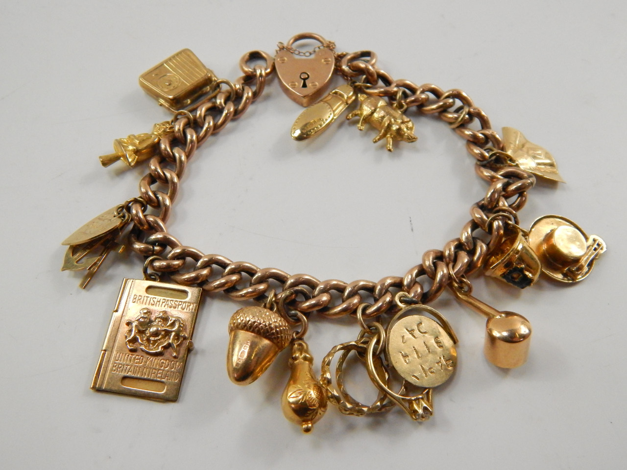 Appraisal: A ct gold kerb link charm bracelet on a heart