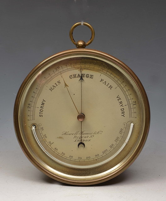 Appraisal: A VICTORIAN ANEROID WALL BAROMETER the silvered dial inscribed Howell