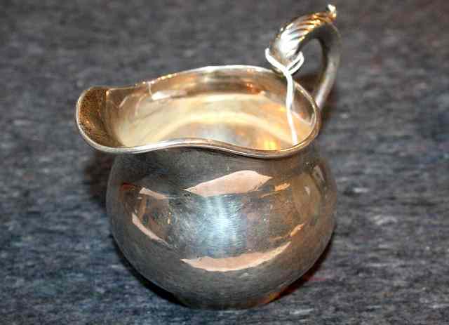 Appraisal: A SILVER GRAVY JUG bulbous shaped standing on a turned