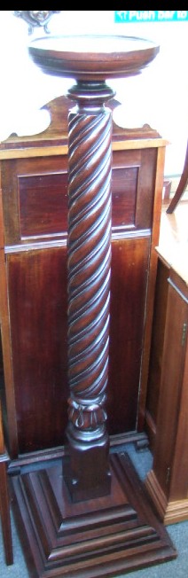 Appraisal: A spirally lobed mahogany torchere stand with turned top and