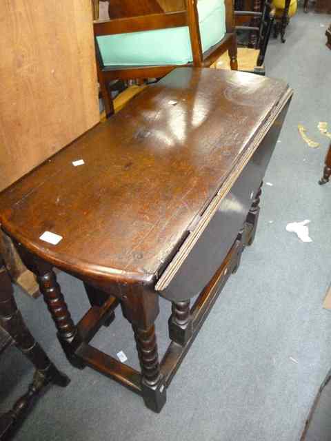 Appraisal: AN ANTIQUE OAK DROP FLAP DINING TABLE standing on bobbin