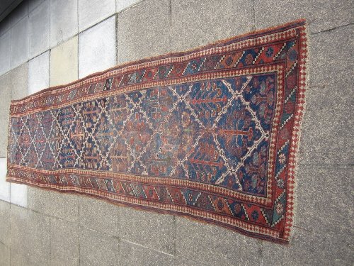 Appraisal: An Oriental runner with floral trellis indigo ground medallions within