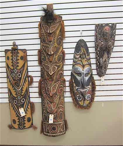 Appraisal: FOUR PAPUA NEW GUINEA TRIBAL WOOD CARVINGS ''L shield ''