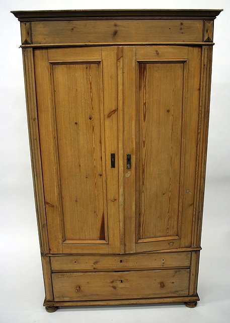 Appraisal: AN OLD PINE TWO DOOR ARMOIRE the twin panelled doors