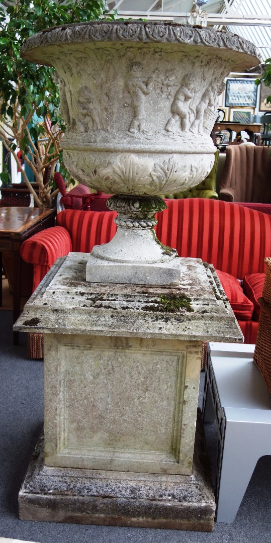 Appraisal: A large composite stone urn the body relief moulded with