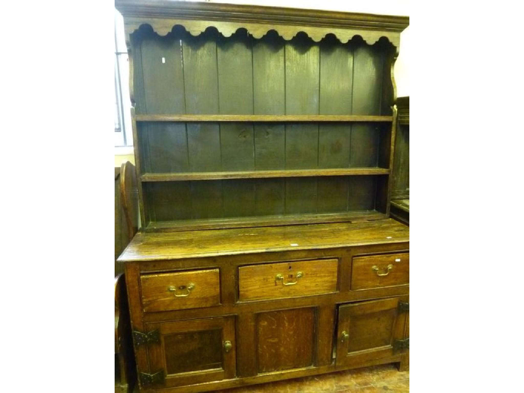 Appraisal: A Georgian oak dresser base fitted with three frieze drawers