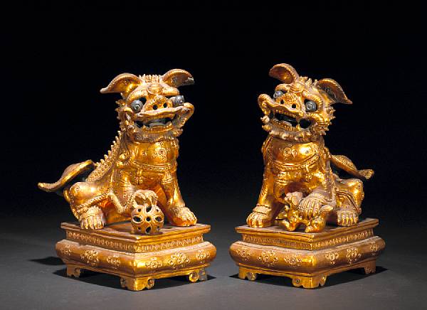 Appraisal: A pair of gilt lacquered pottery fu lions on stands