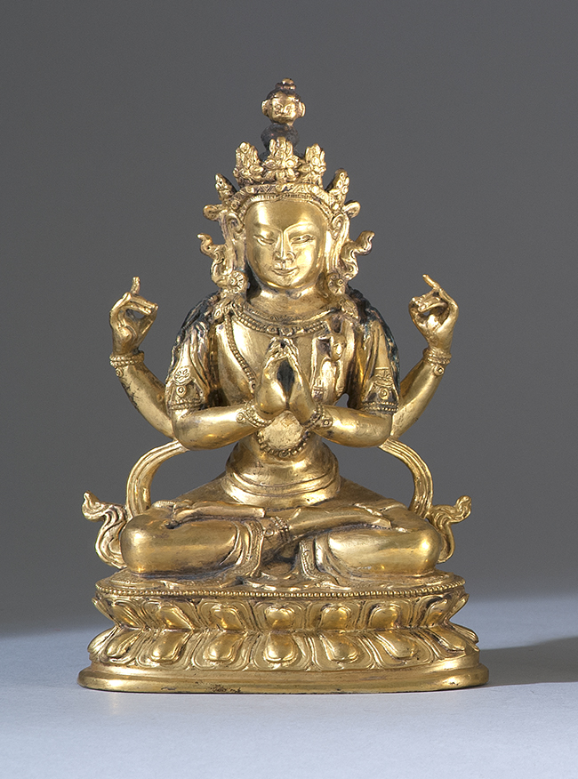 Appraisal: GILT-BRONZE FIGURE Depicting a seated four-armed deity on a double