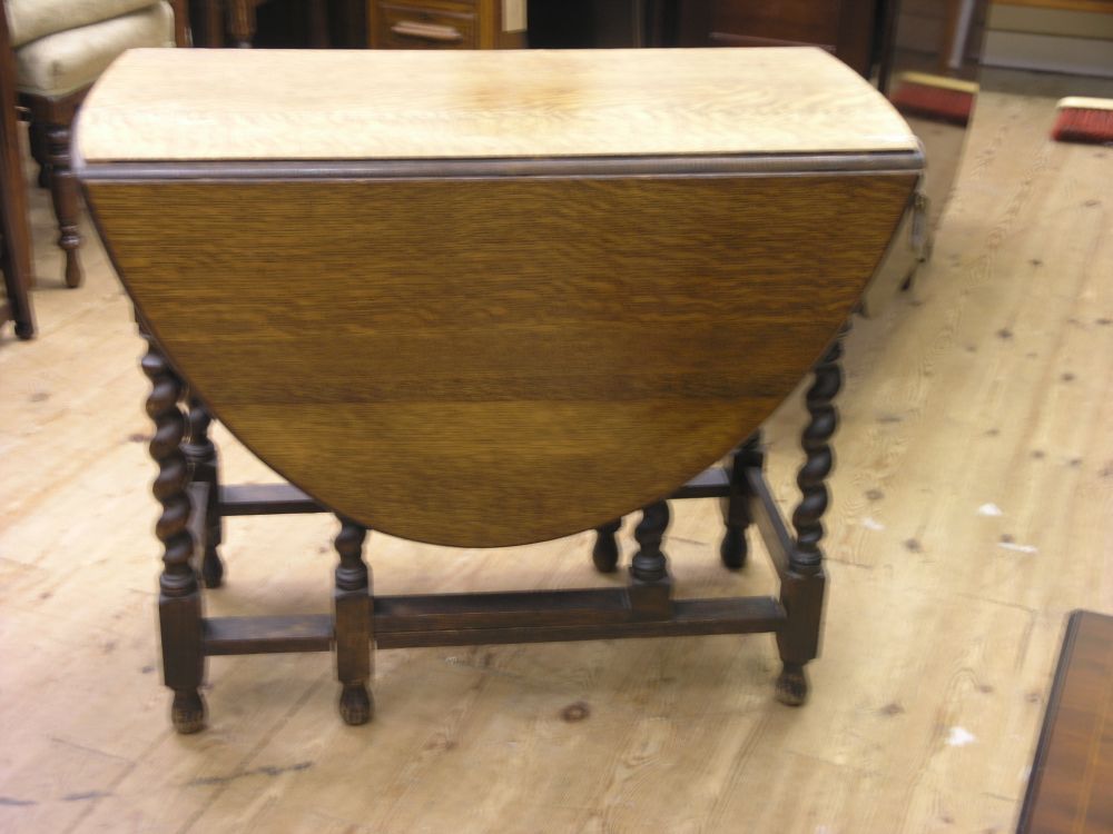 Appraisal: A solid dark oak gateleg table on barley twist underframe