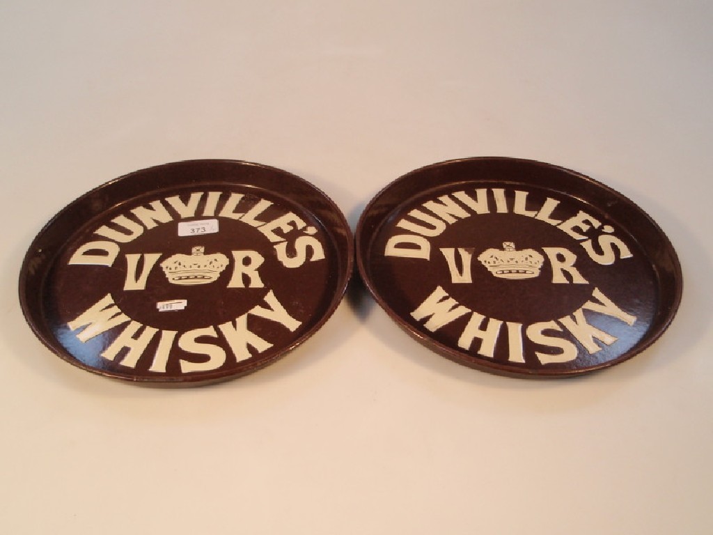 Appraisal: A pair of brown tin circular pub trays enamelled in