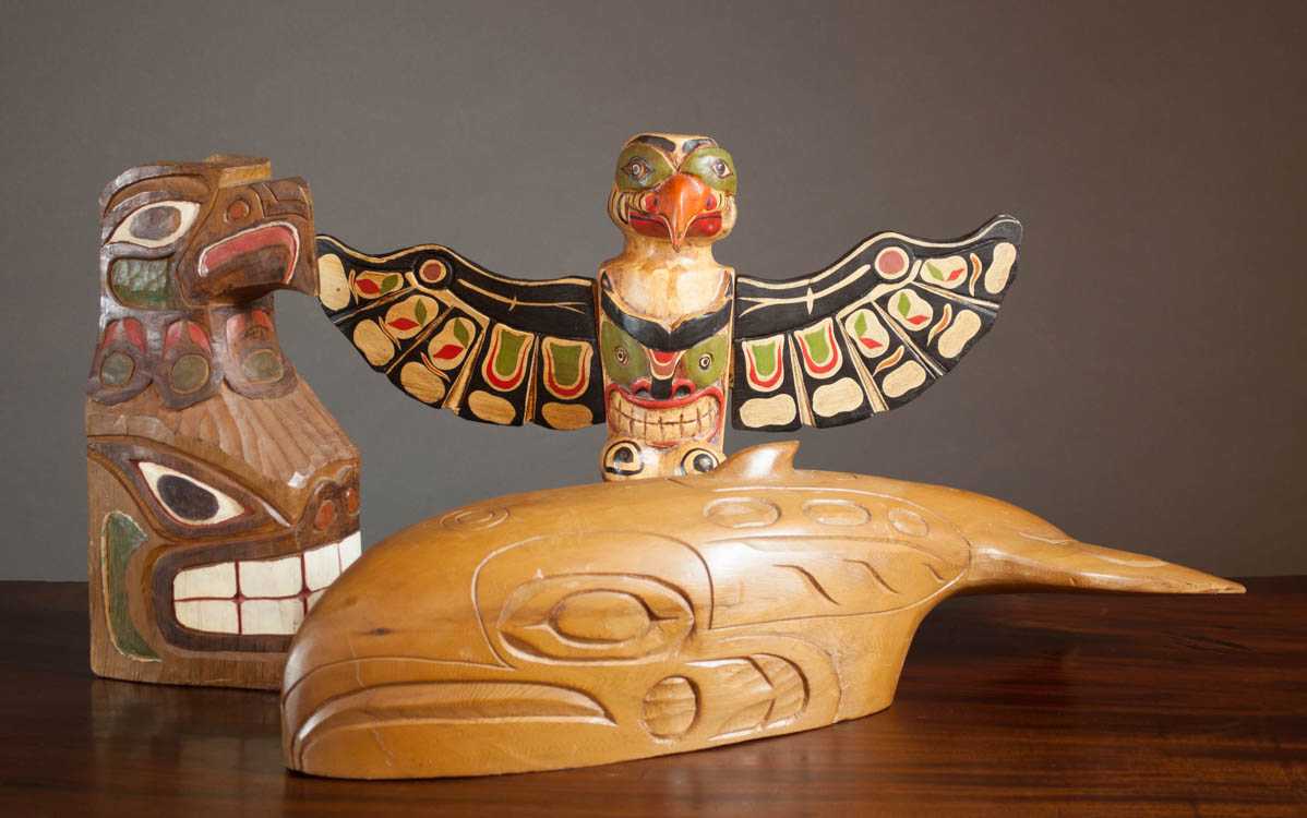 Appraisal: THREE NATIVE AMERICAN CARVED WOOD SCULPTURES a polychrome totem pole