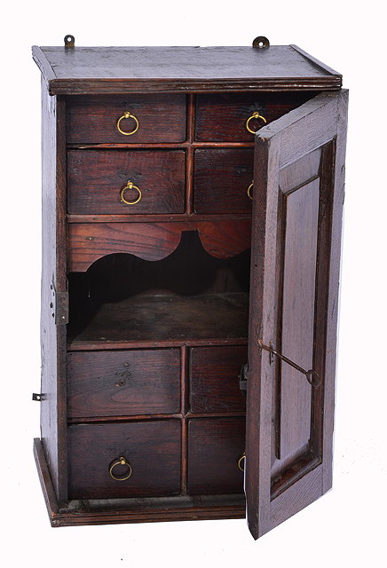 Appraisal: AN ANTIQUE OAK SPICE CUPBOARD the interior fitted with eight