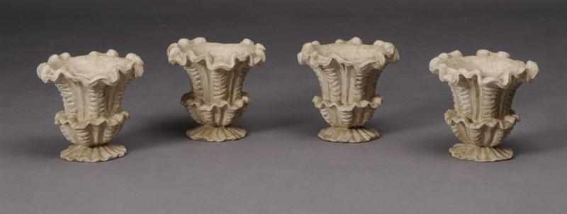 Appraisal: SET OF FOUR ROCOCO STYLE CAST STONE URNS Each shell-cast