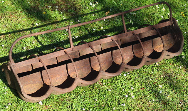 Appraisal: A CAST IRON PIGLET FEEDER with lobed front and looped