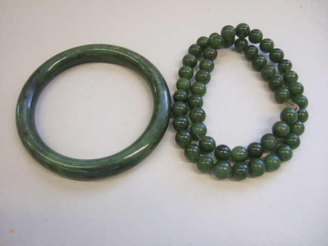 Appraisal: A circular nephrite bangle and a single row necklace of