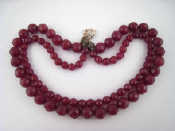 Appraisal: A faceted red bead necklace with white metal tests silver