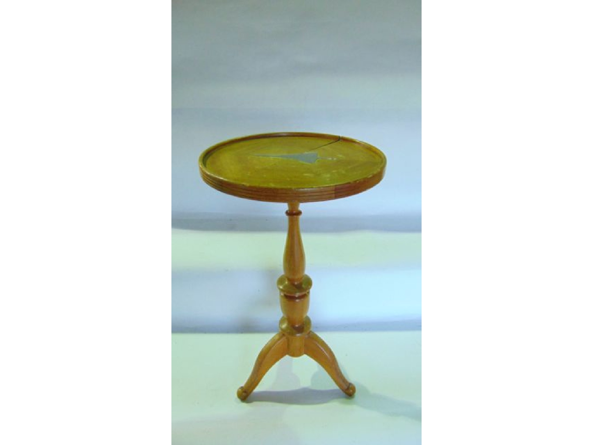 Appraisal: A small wooden wine table with turned column tri support