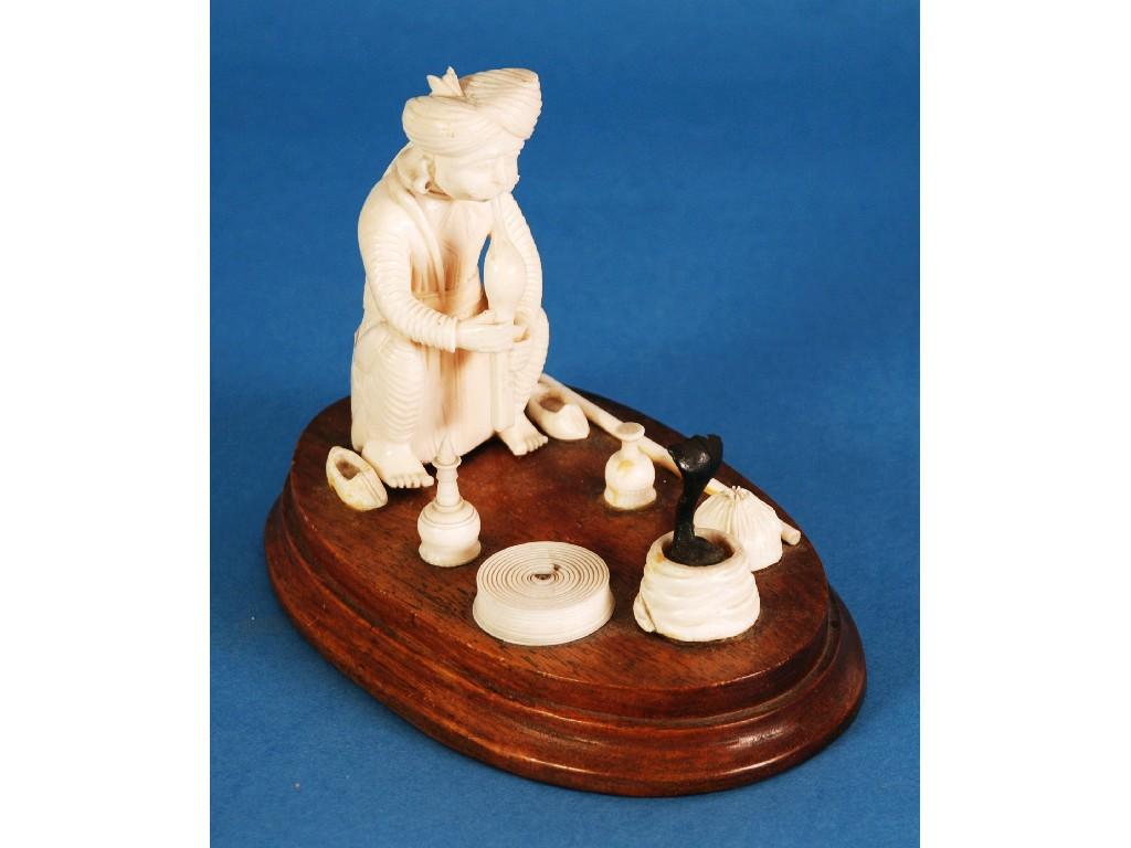 Appraisal: INDIAN CARVED IVORY FIGURE OF A SNAKE CHARMER on a