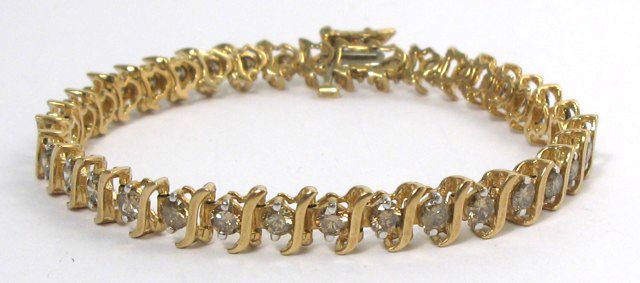 Appraisal: DIAMOND AND FOURTEEN KARAT GOLD LINE BRACELET with S-form links