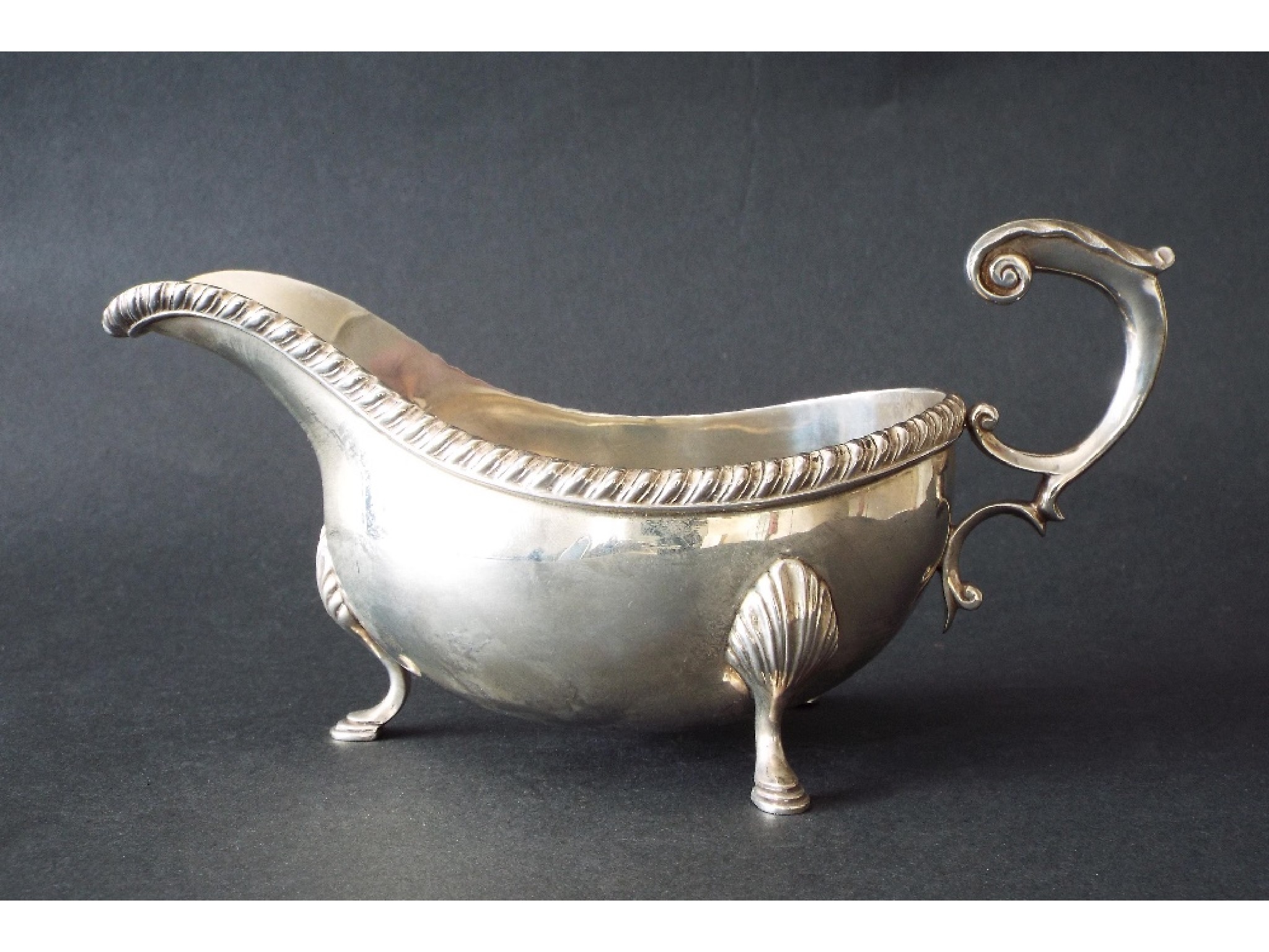 Appraisal: Georgian style silver sauce boat with S-scroll handle gadrooned rim