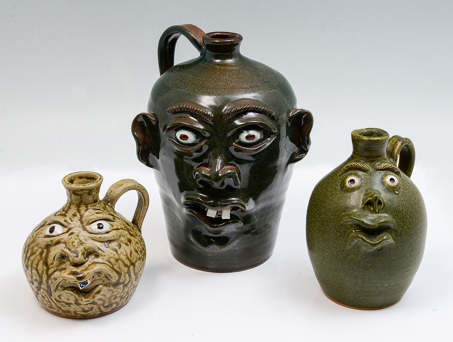 Appraisal: PC MIKE WILLIAMSON POTTERY FACE JUGS Three funny face jugs