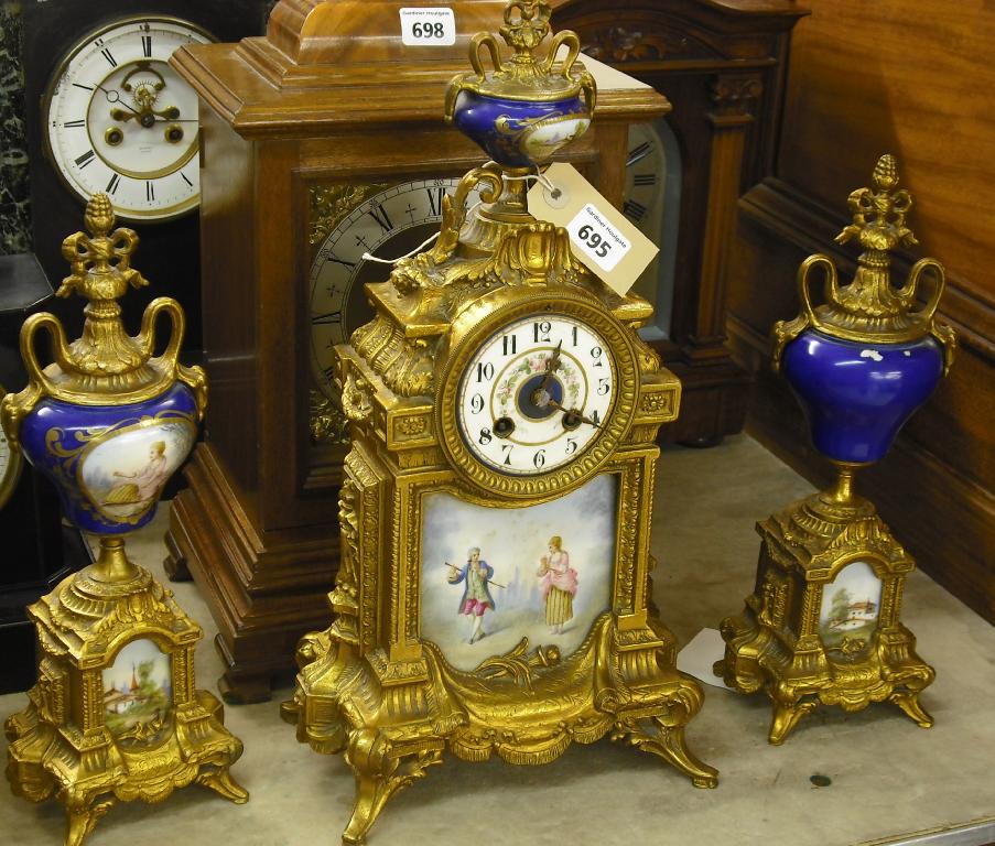 Appraisal: French porcelain and gilded spelter two train clock garniture the