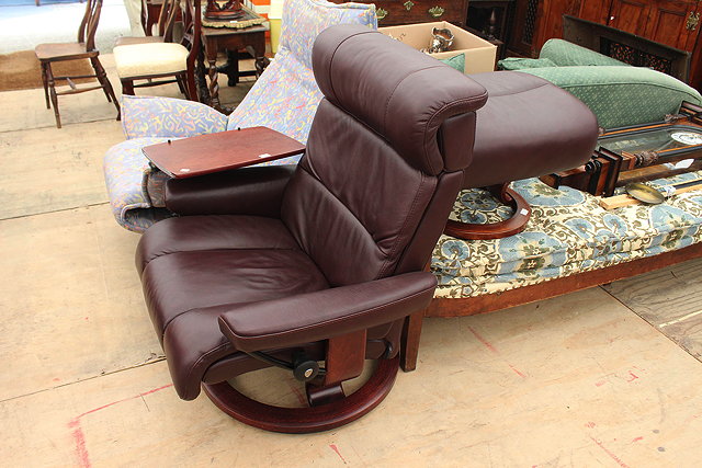 Appraisal: A BROWN LEATHER UPHOLSTERED STRESSLESS RECLINING ARMCHAIR together with a