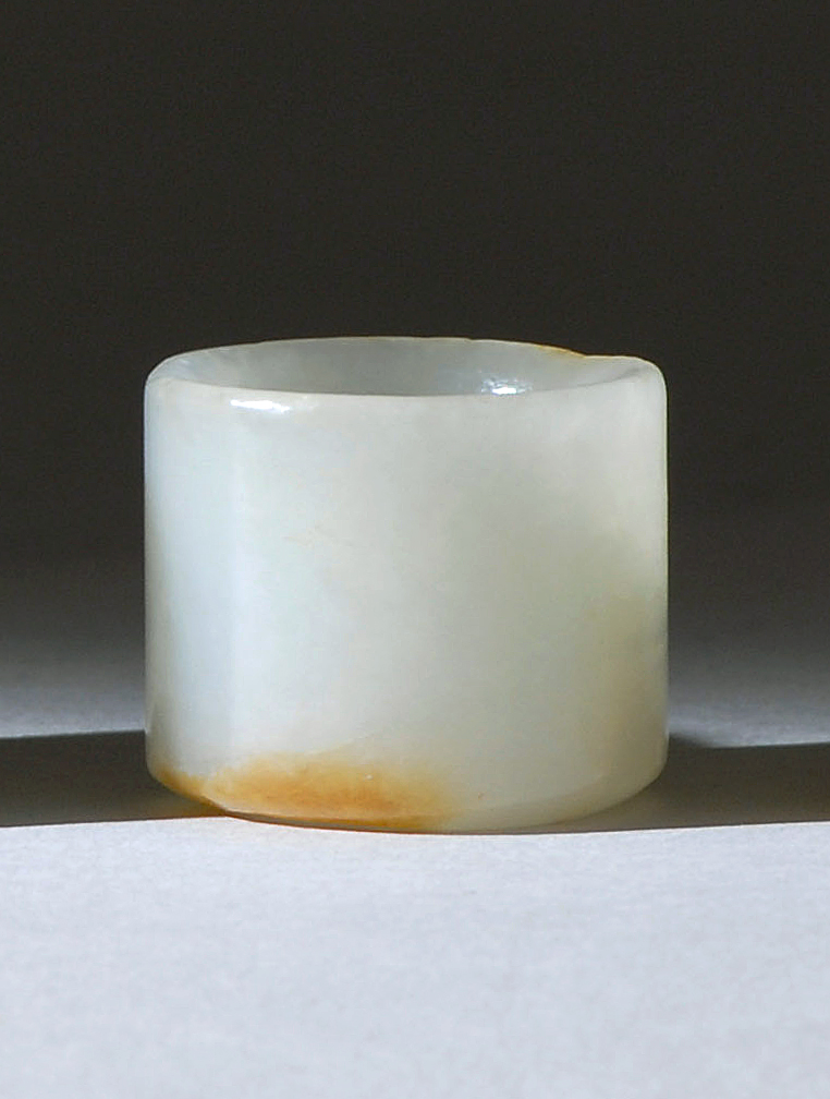 Appraisal: WHITE AND RUSSET JADE ARCHER'S RING Late th CenturyIn cylinder