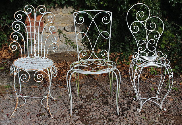 Appraisal: A GROUP OF THREE WHITE PAINTED WROUGHT IRON GARDEN CHAIRS