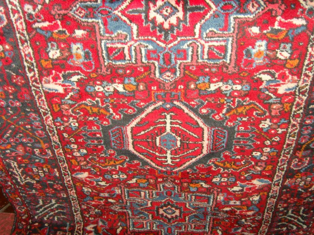 Appraisal: A red ground eastern wool rug with polychrome repeating motifs