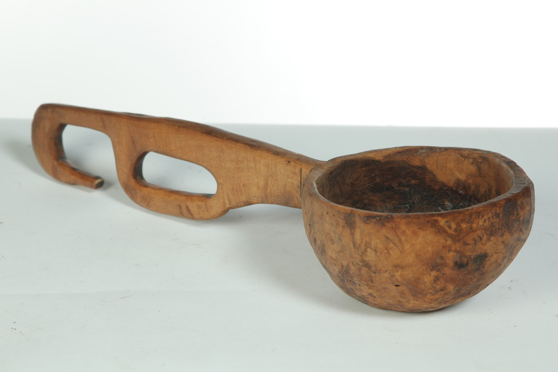 Appraisal: PRIMITIVELY CARVED BURL DIPPER American th century Long open-work handle