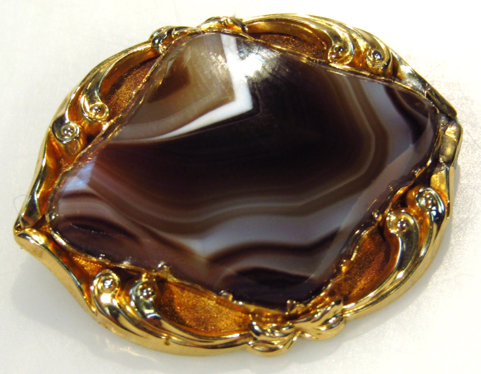 Appraisal: A polished agate brooch of shaped yellow metal outline unmarked