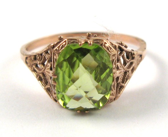 Appraisal: PERIDOT AND FOURTEEN KARAT ROSE GOLD RING centering a checkerboard-cut