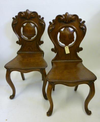 Appraisal: A PAIR OF VICTORIAN MAHOGANY HALL CHAIRS the waisted scroll