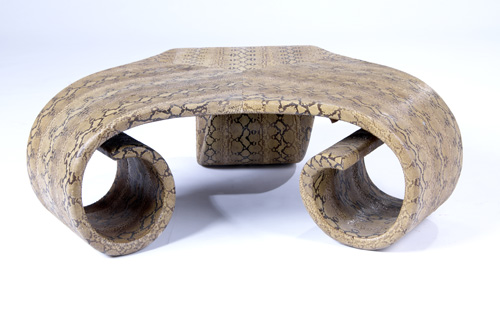 Appraisal: KARL SPRINGER Three-legged coffee table covered in snakeskin Formerly in