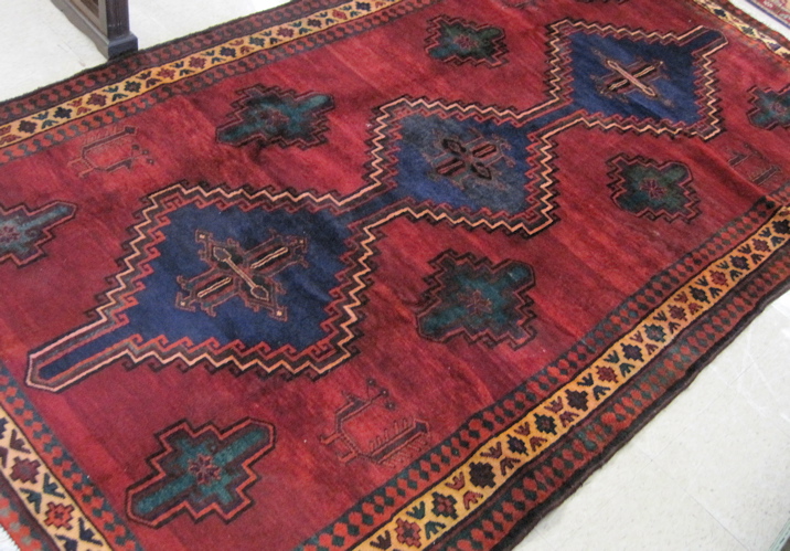 Appraisal: PERSIAN TRIBAL CARPET centering three blue pole medallions on plain