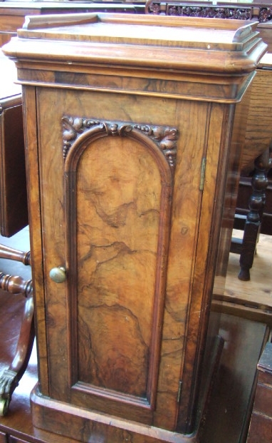 Appraisal: A mid Victorian walnut bedside pot cupboard with a carved