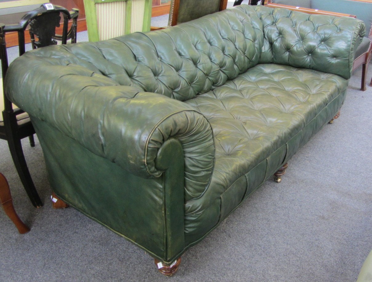 Appraisal: A Victorian green leather upholstered low buttonback Chesterfield sofa on