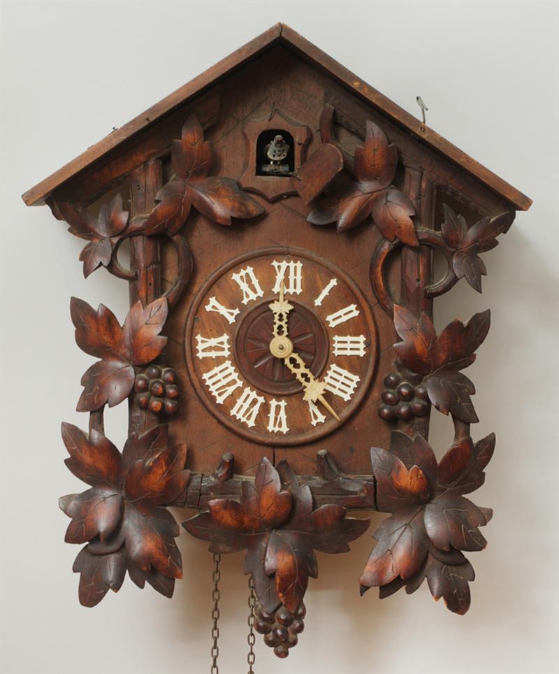 Appraisal: Black Forest Leaf Carved Cuckoo Clock With cast-iron pine cone