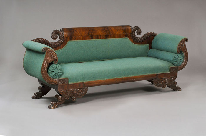 Appraisal: AMERICAN CLASSICAL CARVED FIGURED MAHOGANY SOFA The rolled figured crest