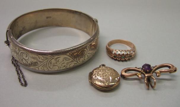 Appraisal: A silver oval hinged bangle with scroll engraved decoration to