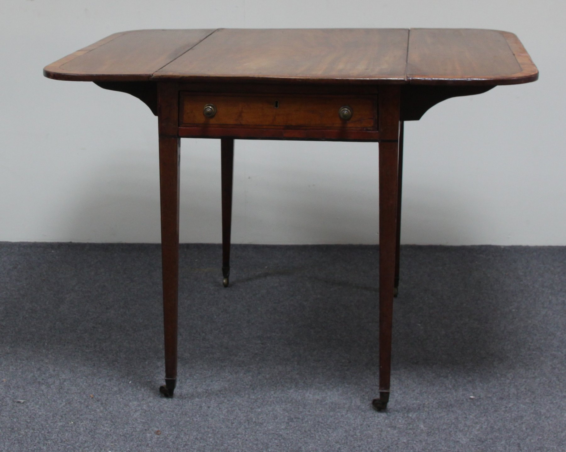 Appraisal: A George III mahogany Pembroke table crossbanded and fitted a