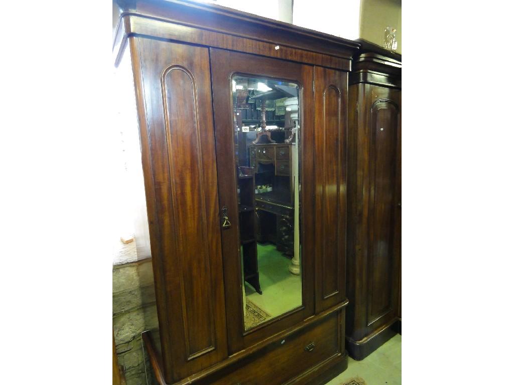 Appraisal: A Victorian mahogany wardrobe enclosed by a central arched mirror