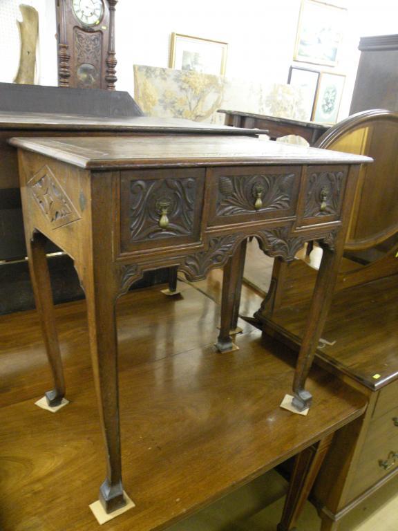 Appraisal: A late thC oak lowboy later carved with foliate scrolls