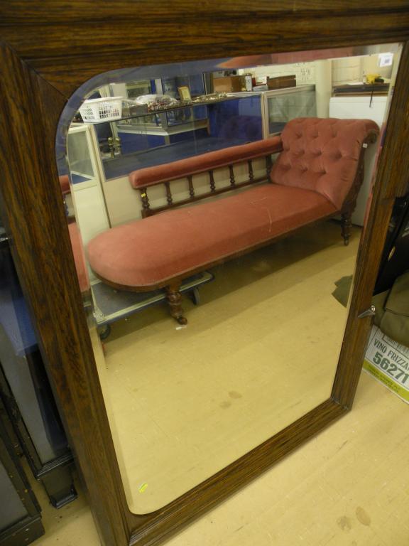 Appraisal: An Edwardian oak rectangular wall mirror with bevelled plate